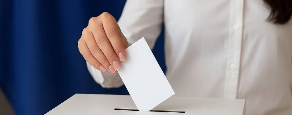 essoa inserindo um voto em urna durante as eleições para comitês de bioética.