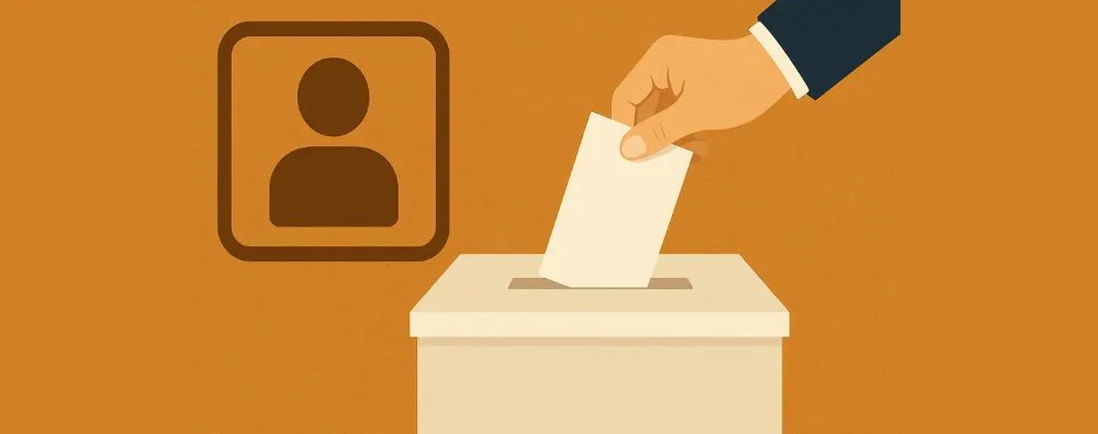 Mão inserindo uma cédula em urna de votação, representando eleições para ouvidoria ou corregedoria interna.